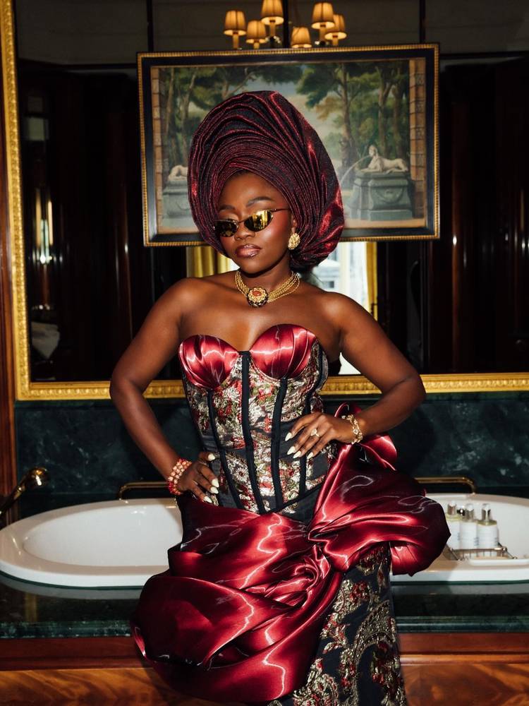 Fisayo Alonge in a burgundy satin gele, standing portrait
