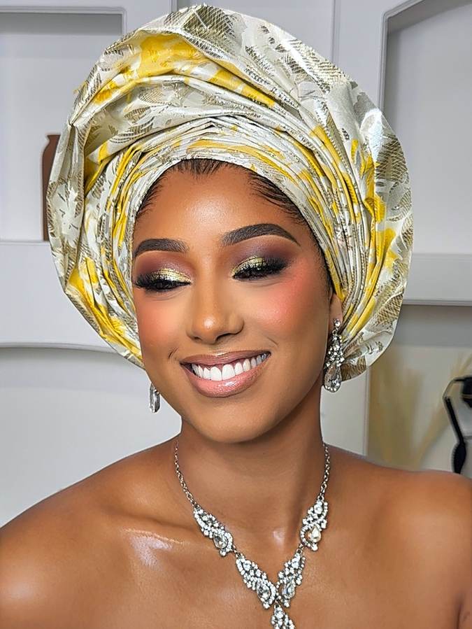 Client in a gold and yellow patterned gele